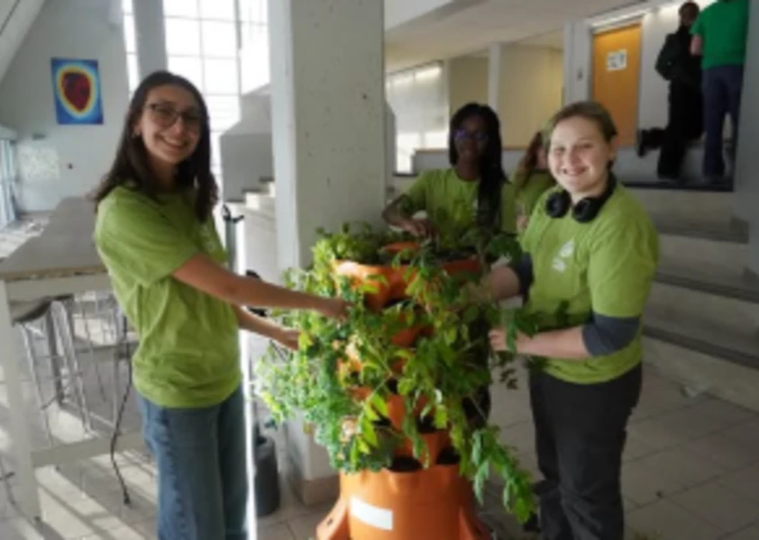 Des élèves devant une station de plantes vertes
